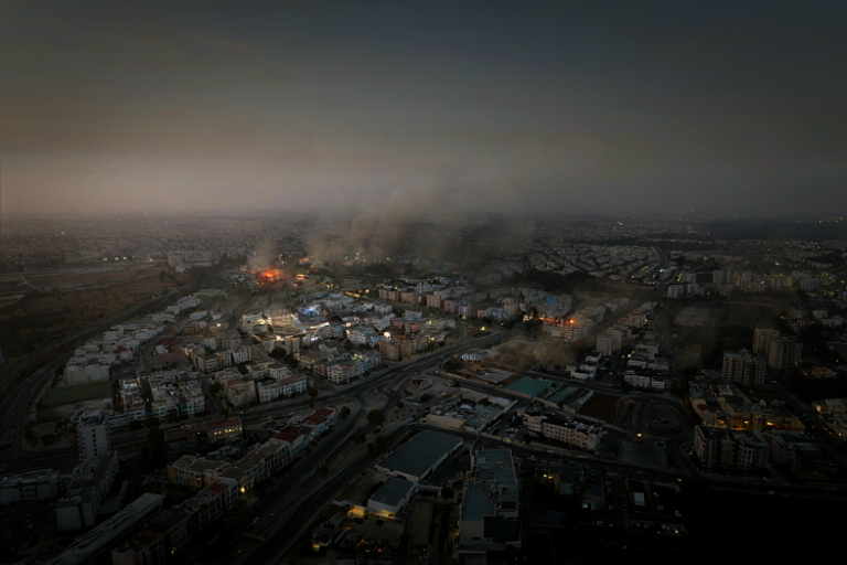 Conceptual illustration of a suburban landscape under a dark sky with distant smoke plumes, suggesting a large-scale aerial event.