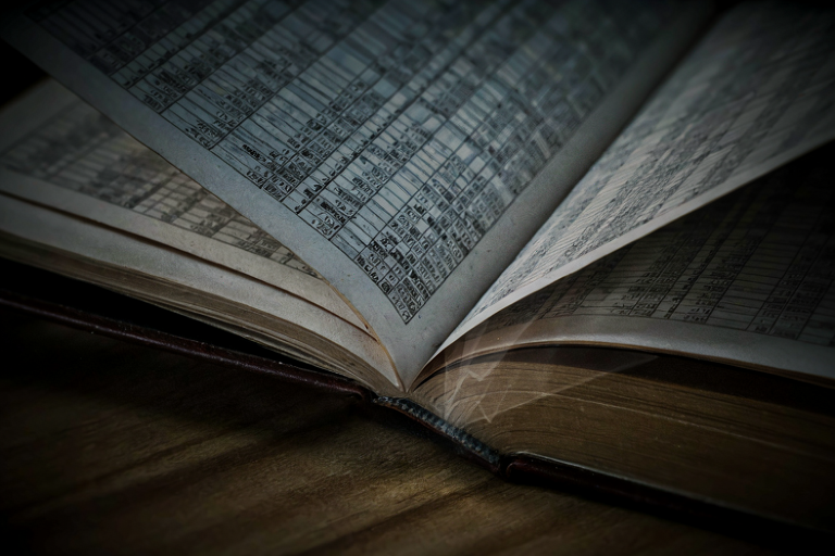 Editorial illustration of a large, open financial ledger on a dark wooden surface, illuminated by a focused beam of light, symbolizing a significant financial deficit and future projections.