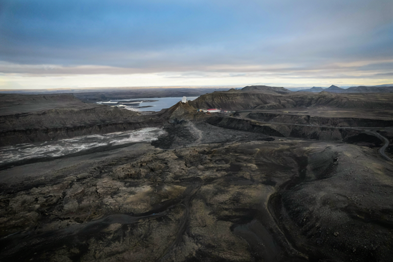 A wide editorial illustration of a stark, rugged Icelandic landscape with volcanic rock meeting glacial ice, suggesting a strategic northern outpost.