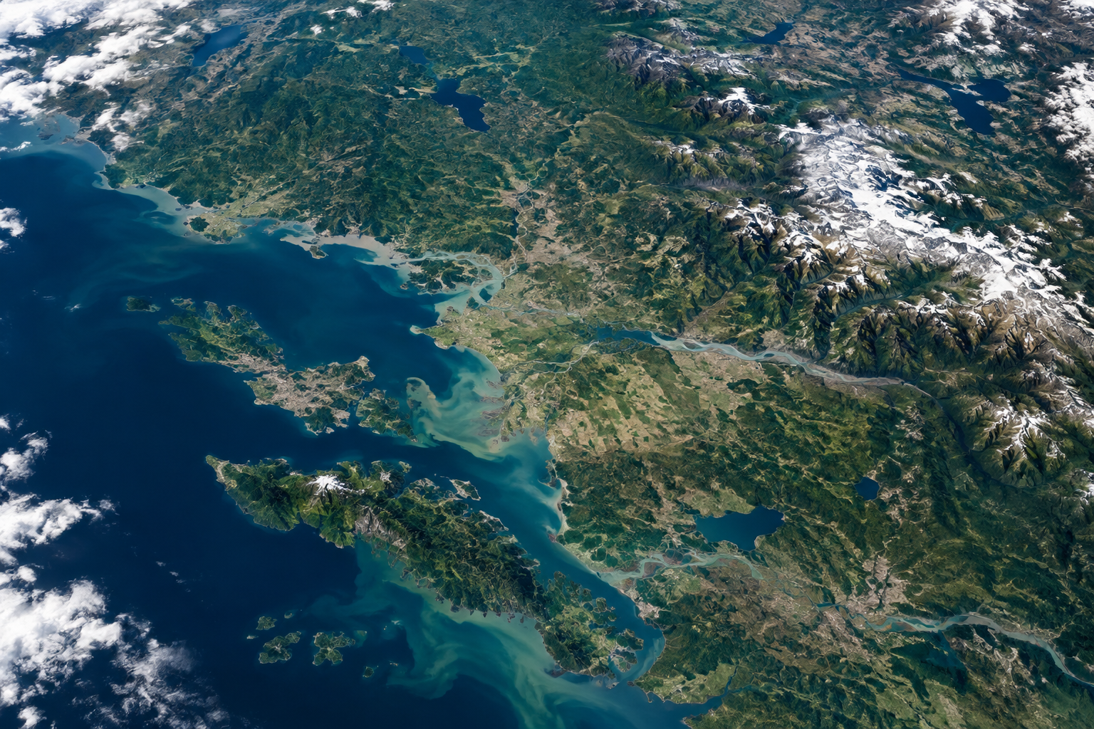 A high-angle satellite view of a textured, varied landscape under bright, clear lighting.