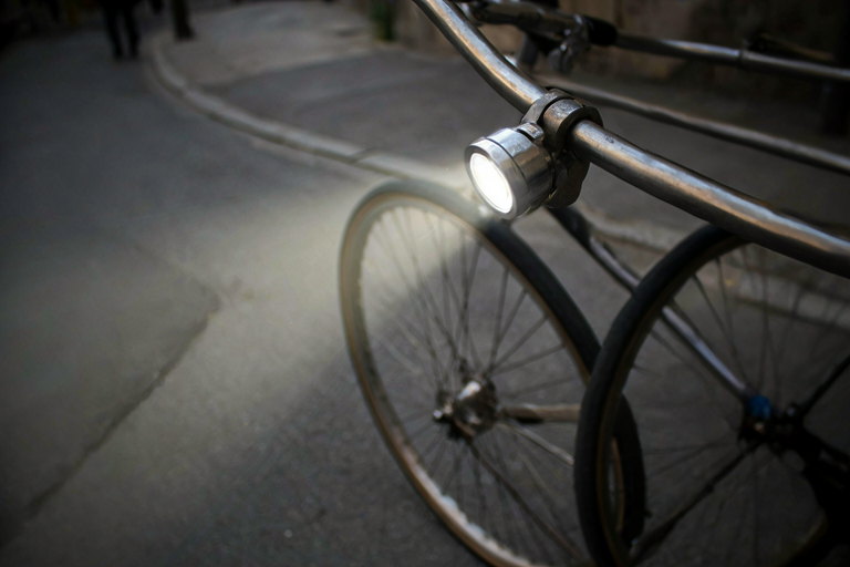 A bicycle with a front light on a dark street, suggesting a traffic violation.