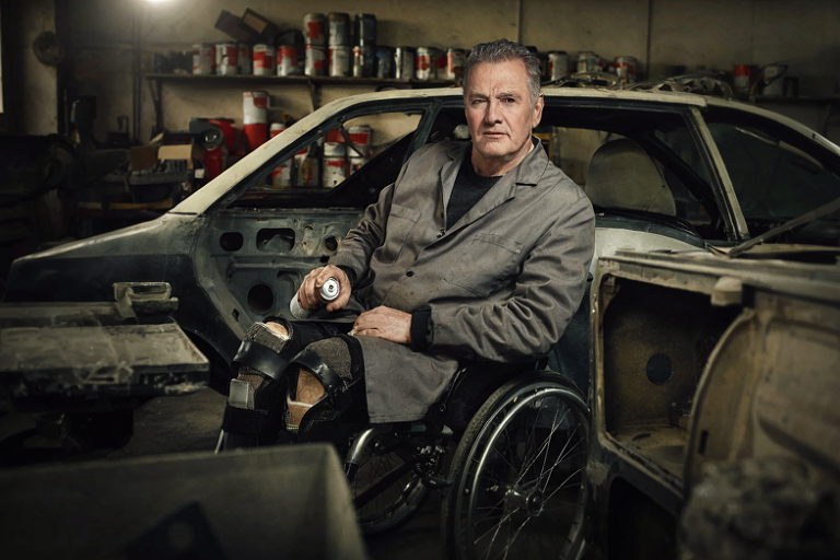Wheelchair-bound painter working on a Fielder Wagon restoration