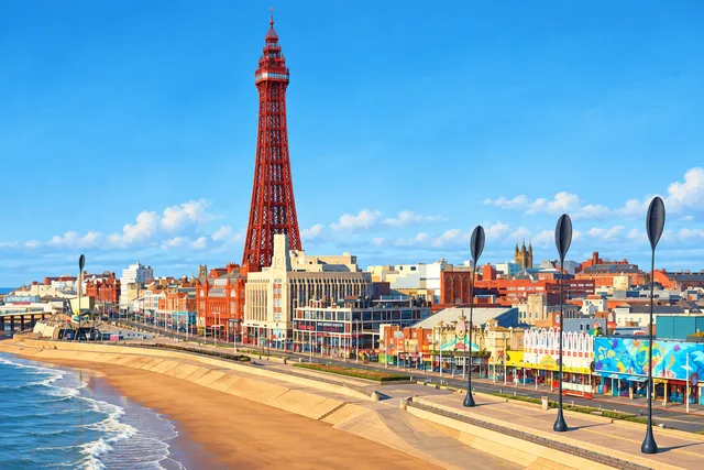 AI illustration based on reference photographs; not an event photograph. A tall, red, lattice-style tower with a pointed top, set against a clear blue sky, surrounded by a cityscape.