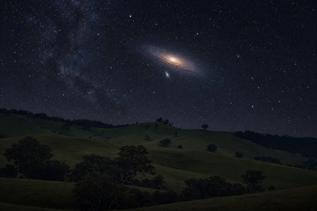 AI illustration based on reference photographs; not an event photograph. Editorial illustration of the Andromeda Galaxy as a faint, fuzzy patch in a starry night sky above dark, rolling hills.