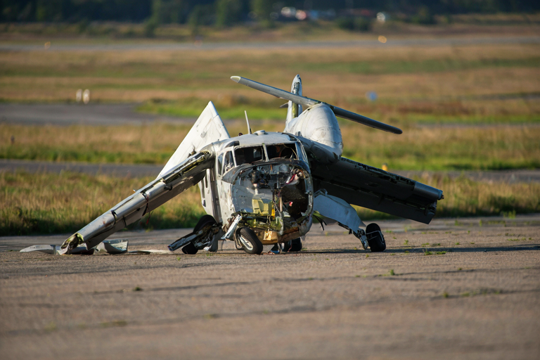 Damaged aircraft on an airstrip with blurred background