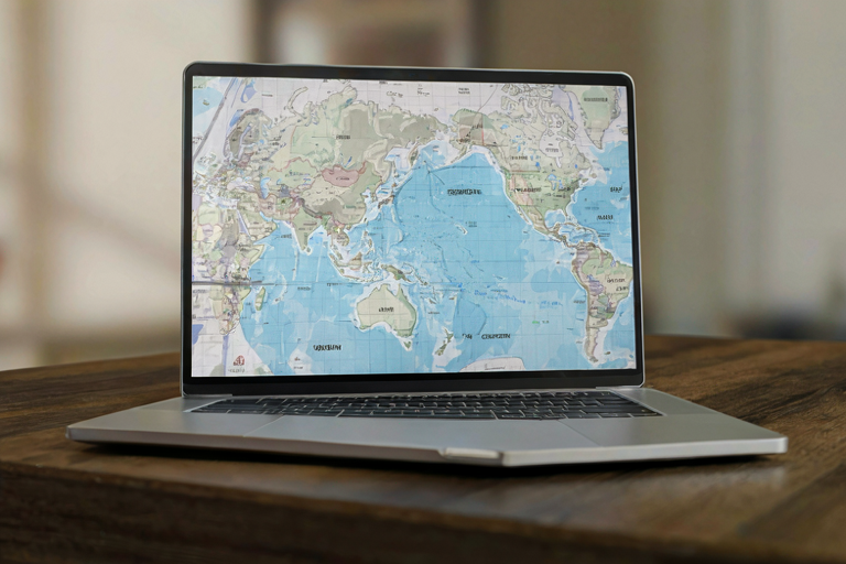 A white laptop displaying a blurred world map highlighting global production regions.